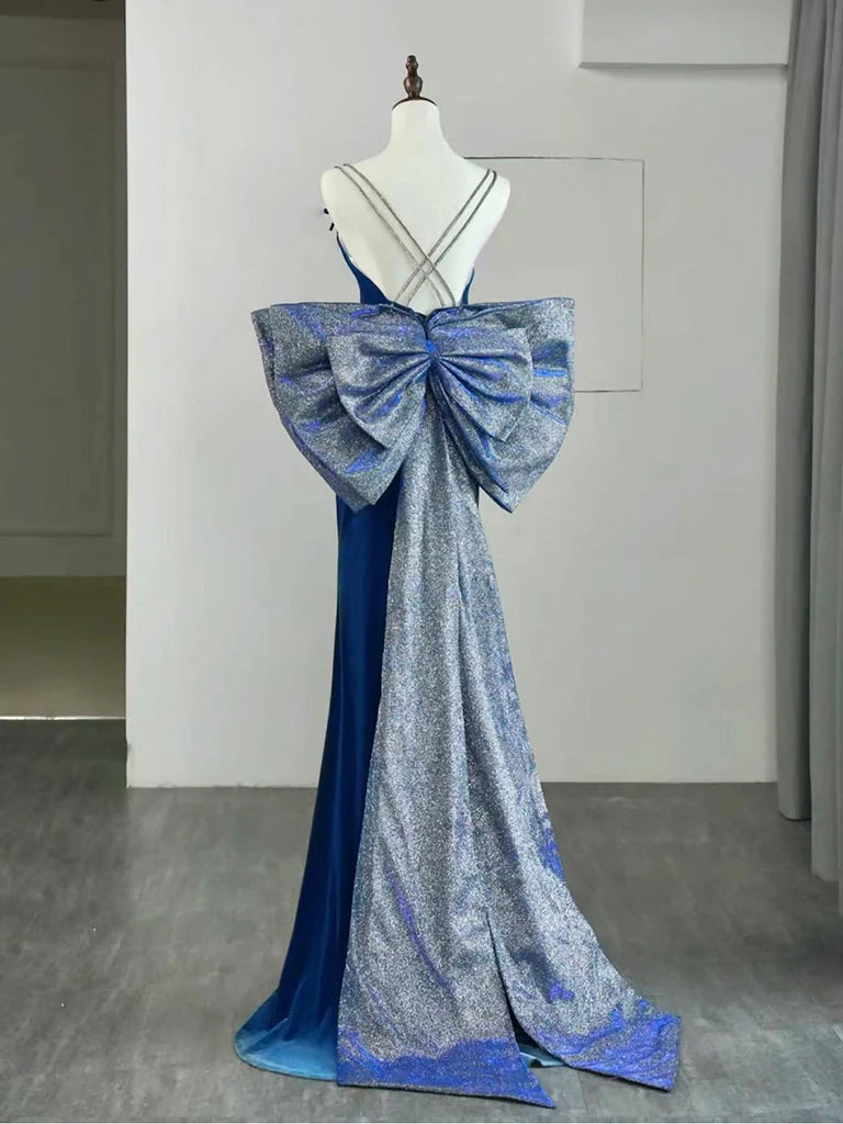 Woman posing gracefully in a blue velvet slim-fit evening gown.