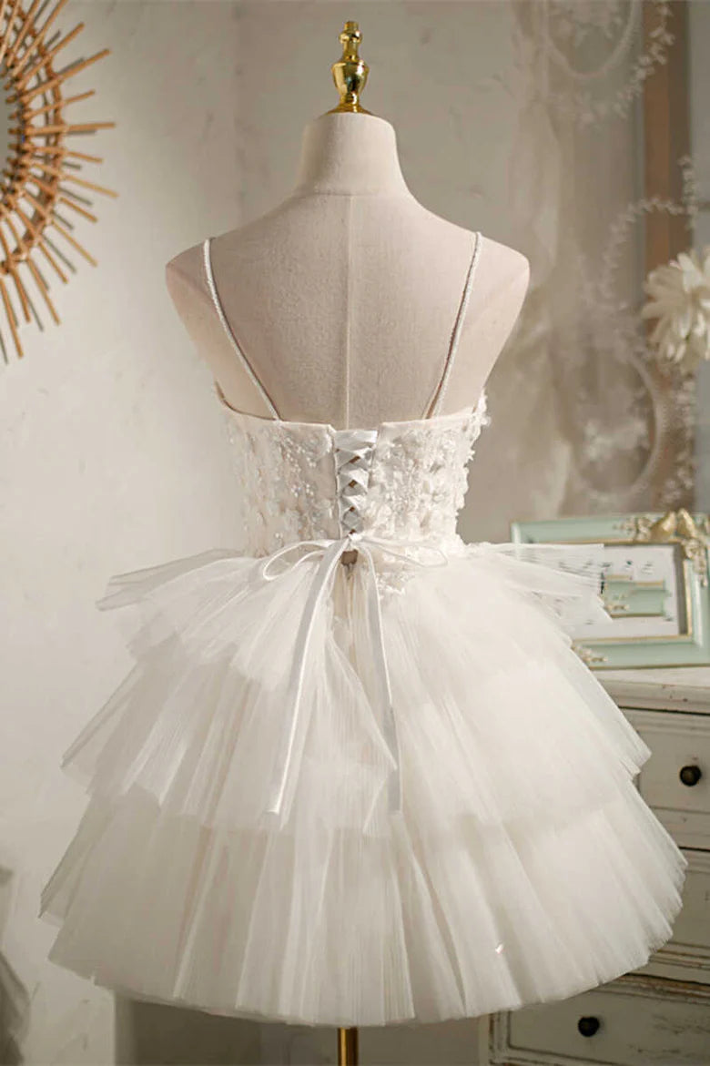 Side view of white multi-tiered tulle short party dress, showing tiered skirt.