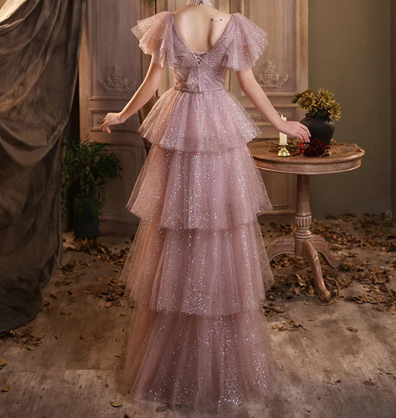 Side view of a pink waist-cinching multilayer floor-length evening dress, showing skirt detail.