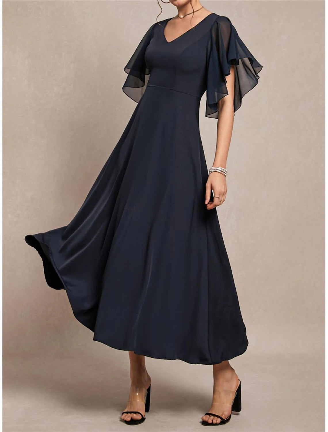 Woman wearing an elegant navy blue A-line maxi dress with V-neck and short sleeves.