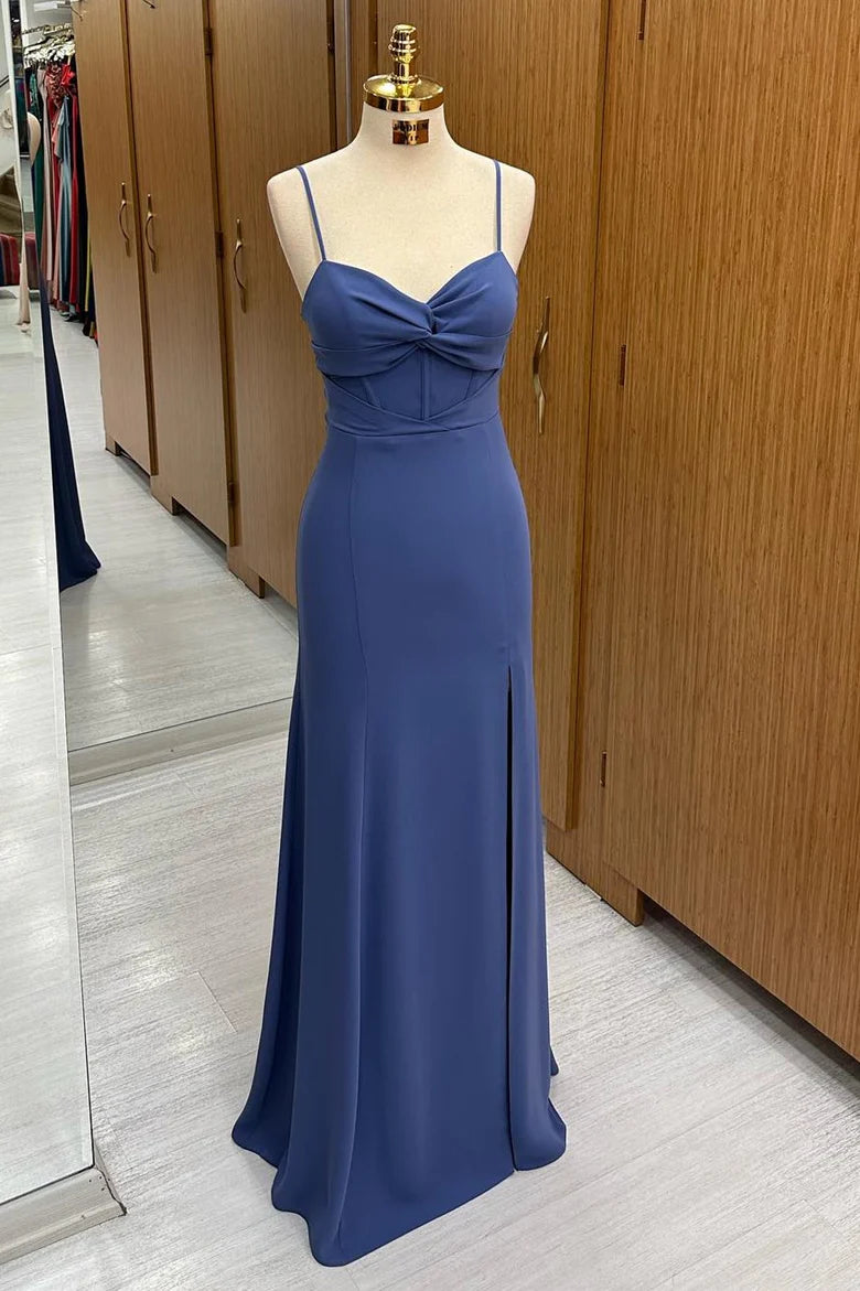Model wearing an elegant navy twist-front formal dress with a long side slit and spaghetti straps.