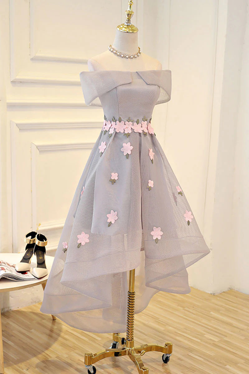 Model wearing a gray off-shoulder high-low prom dress with applique details.