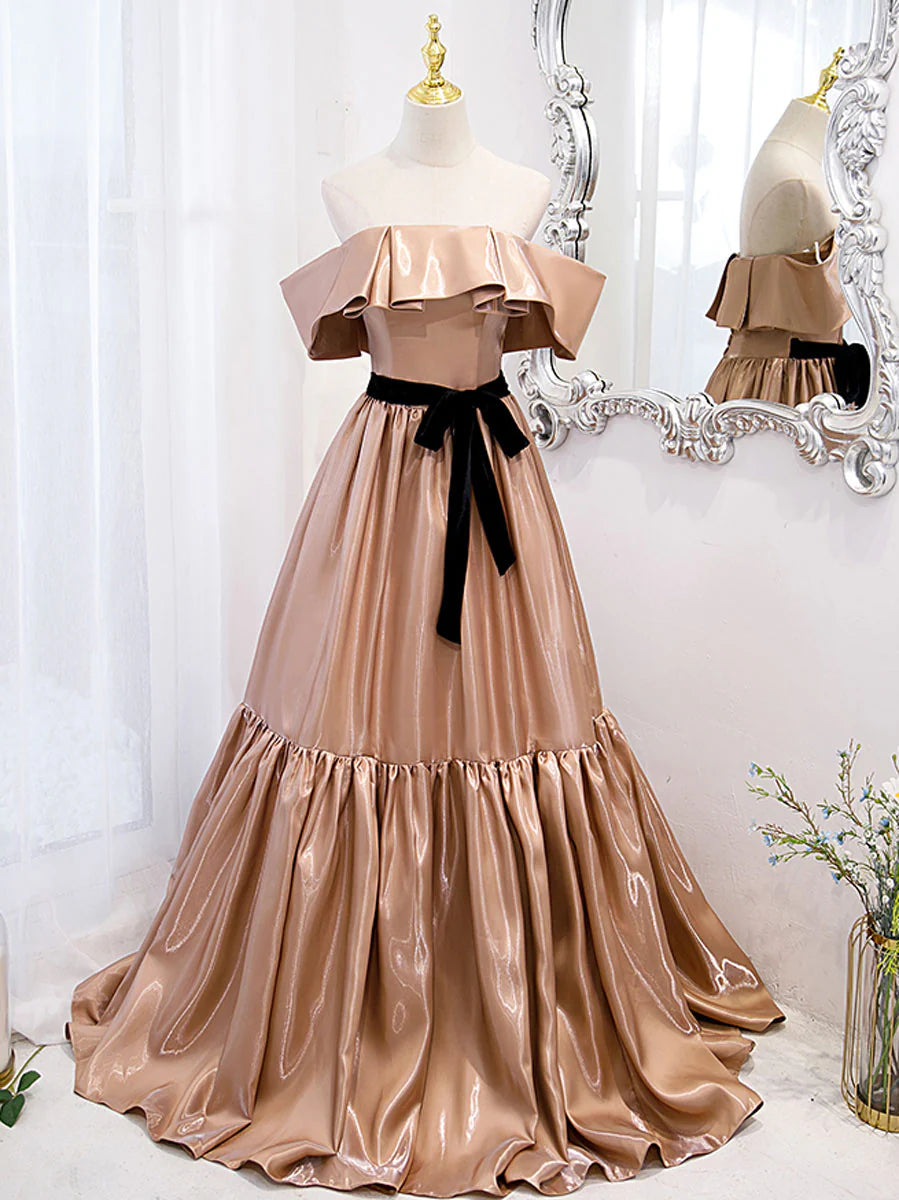 Woman posing in an elegant champagne off-shoulder long prom dress.