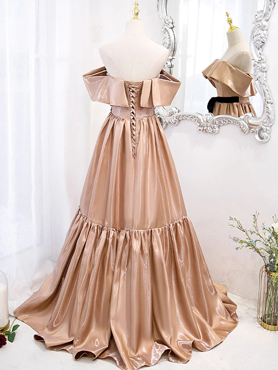 Side profile of a woman wearing a long champagne formal gown.