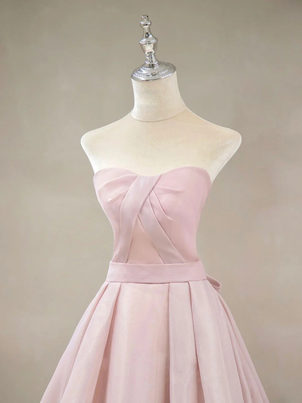 Side view of pink off-shoulder A-line long prom dress with flowing skirt.