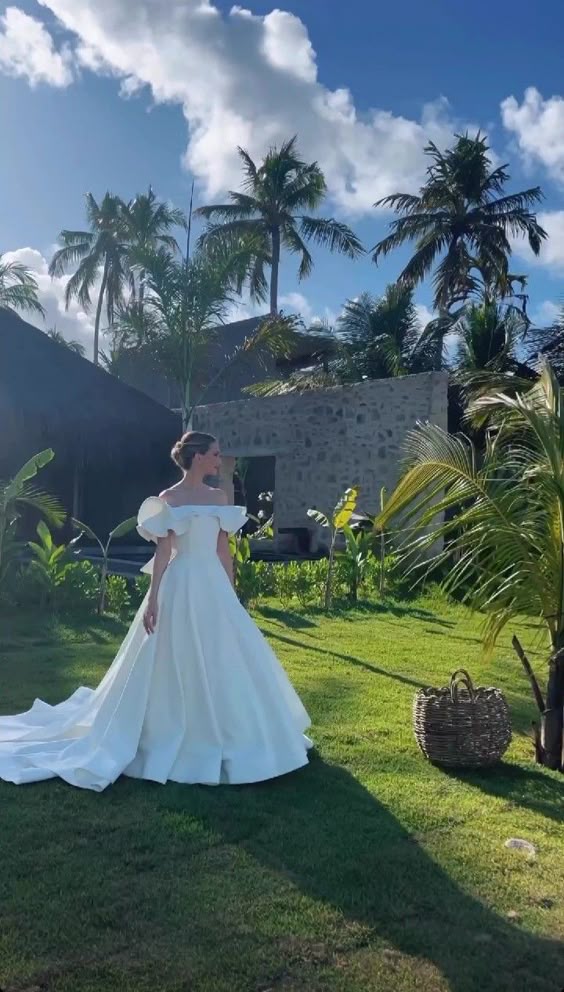 Model wearing an elegant white off-shoulder A-line satin wedding gown.