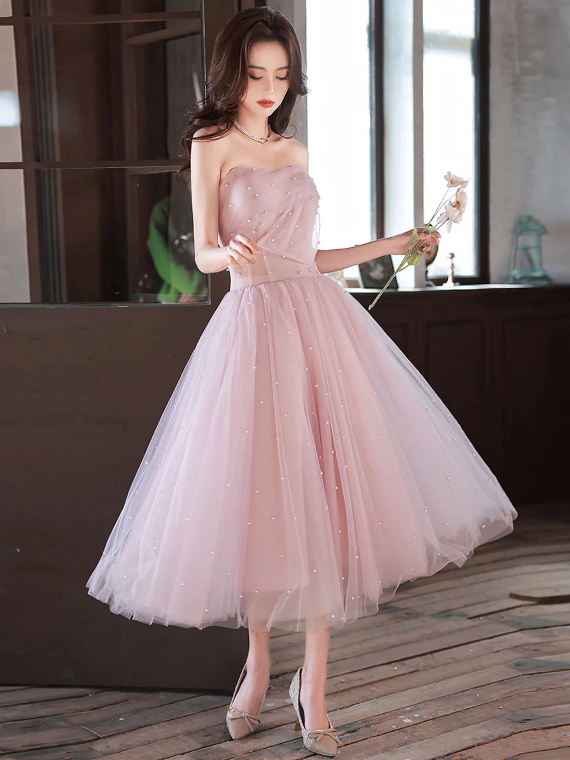 Model wearing an elegant pink off-shoulder A-line tea length prom dress.
