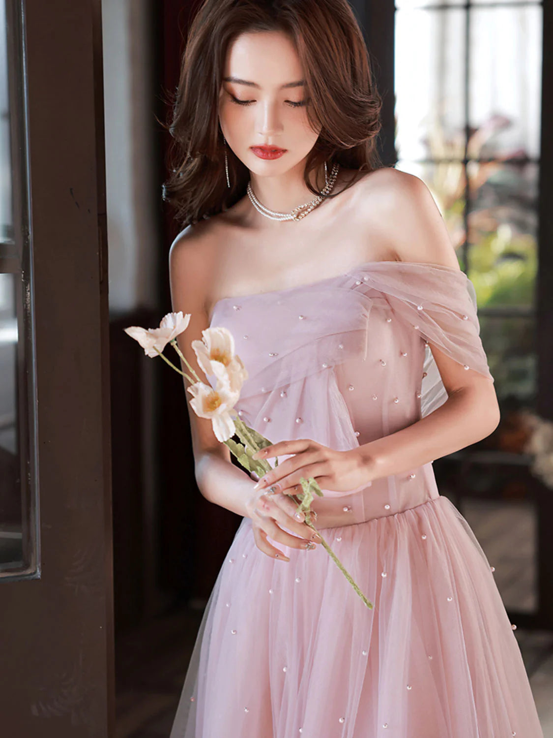 Model showcasing a pink off-shoulder A-line tea length formal dress.