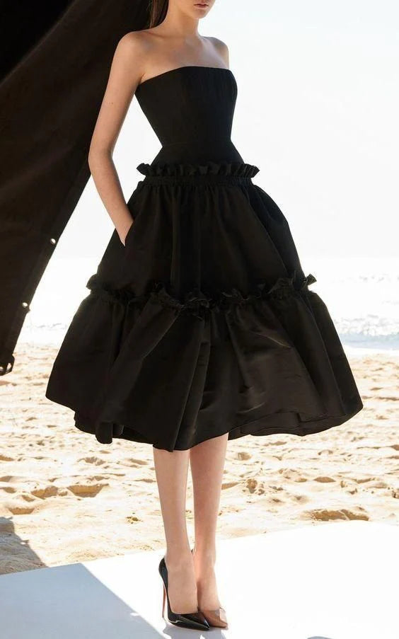 Woman wearing an elegant off-shoulder black satin prom dress.