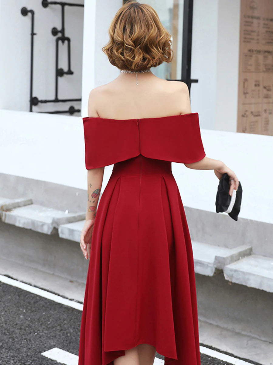 Full-length view of a woman in a sophisticated off-shoulder burgundy evening gown.