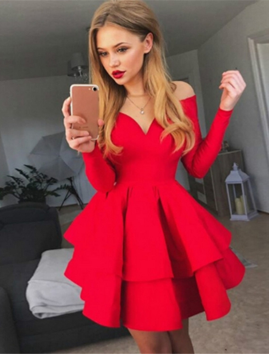 Woman wearing an elegant off-shoulder long sleeve pleated party dress, front view.