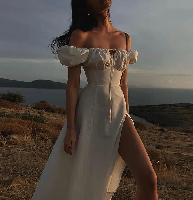 Woman wearing an elegant off-shoulder puff sleeve long prom dress in a light pastel color.
