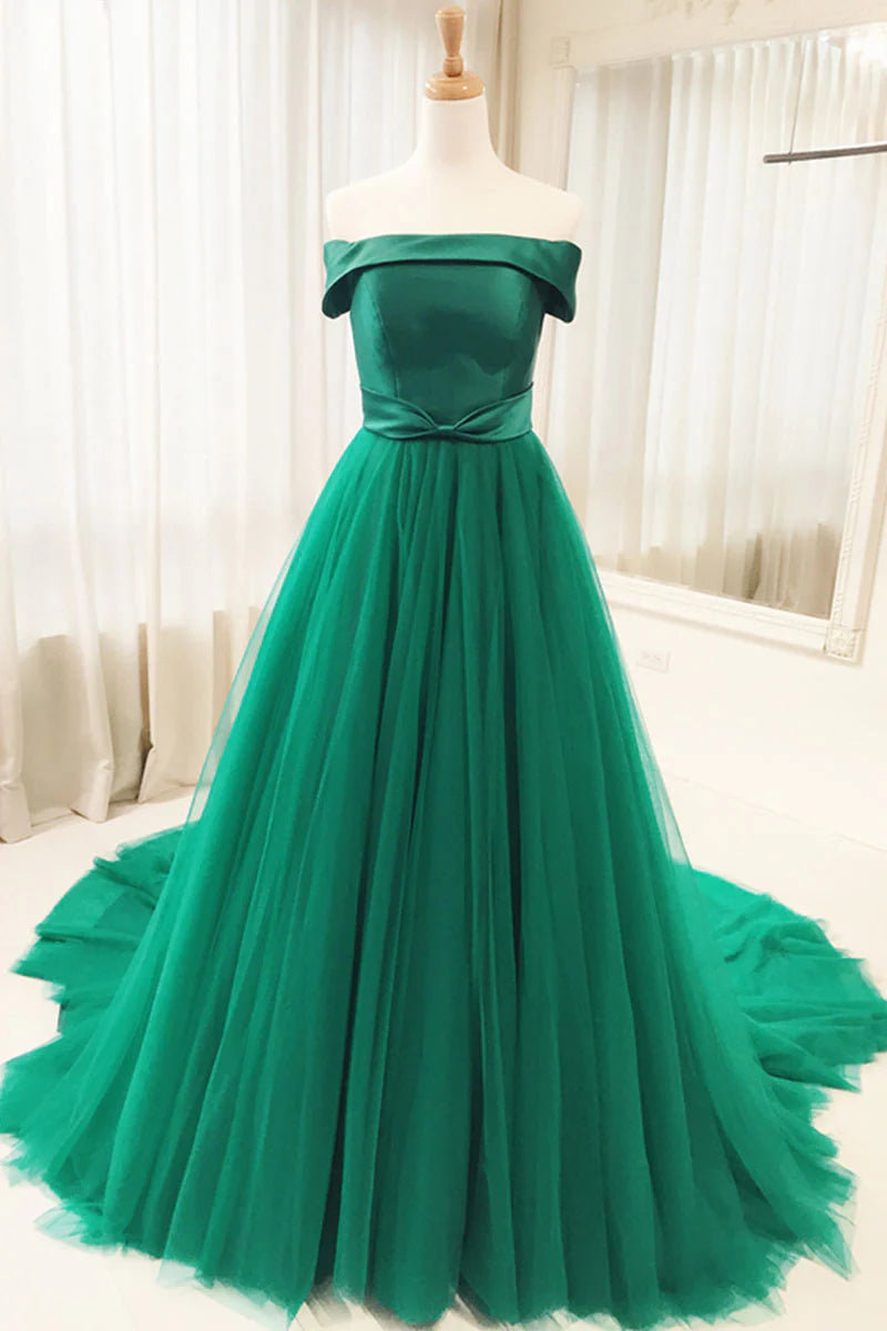 Woman wearing an elegant off-shoulder green tulle long prom dress.