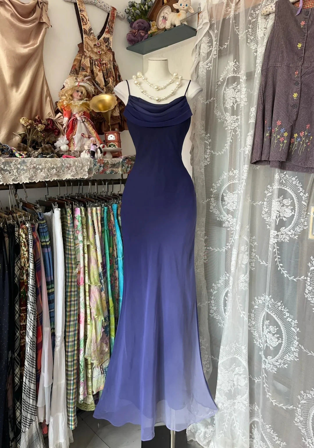 Woman wearing an elegant ombre chiffon mermaid prom gown with spaghetti straps.