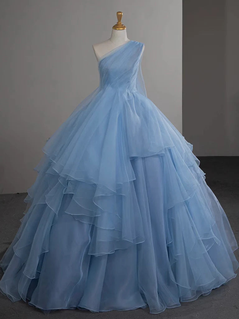 Woman wearing a blue one-shoulder tulle ball gown prom dress.