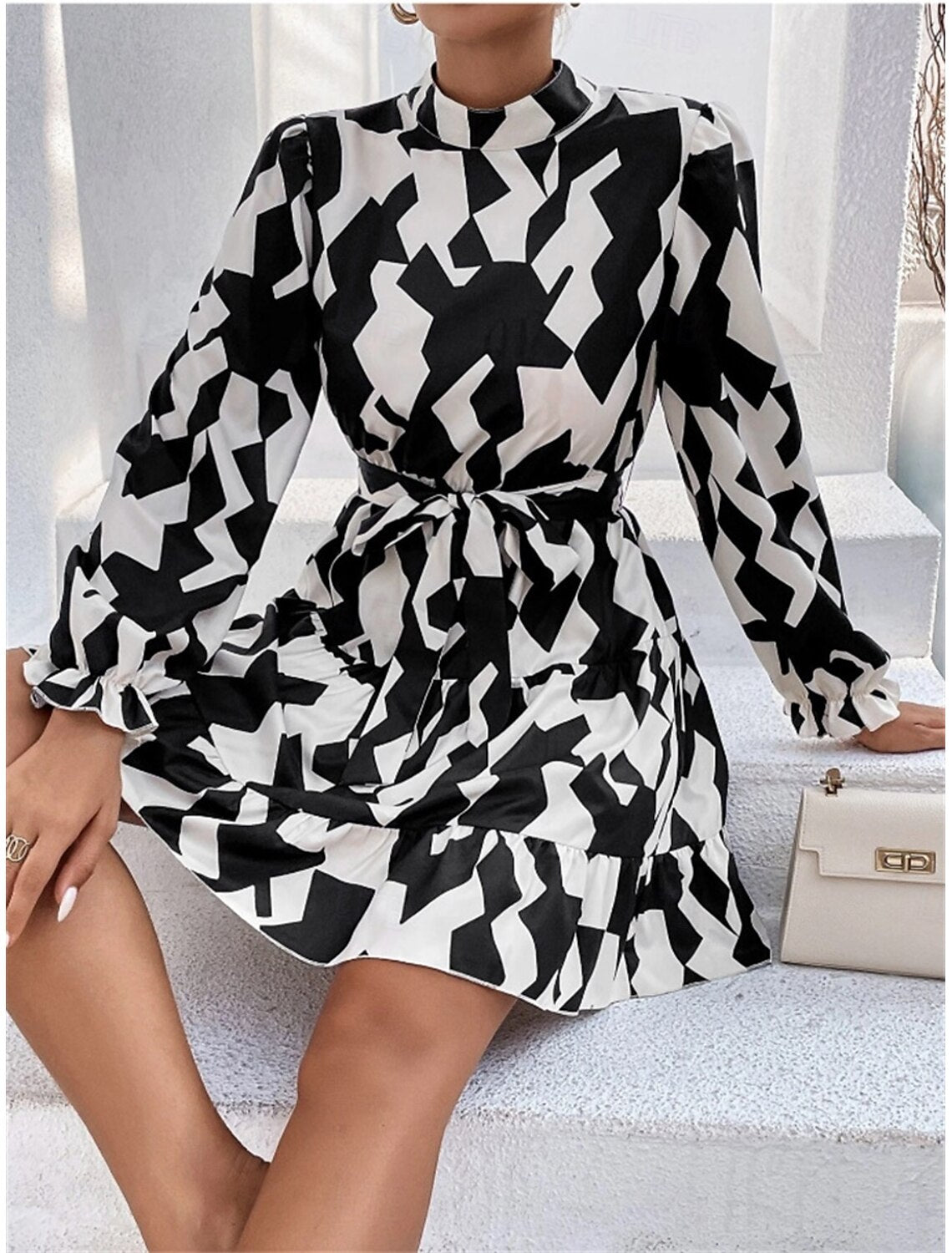 Front view of a woman wearing an elegant dark petite A-line ruffle graphic long sleeve stand collar party dress.