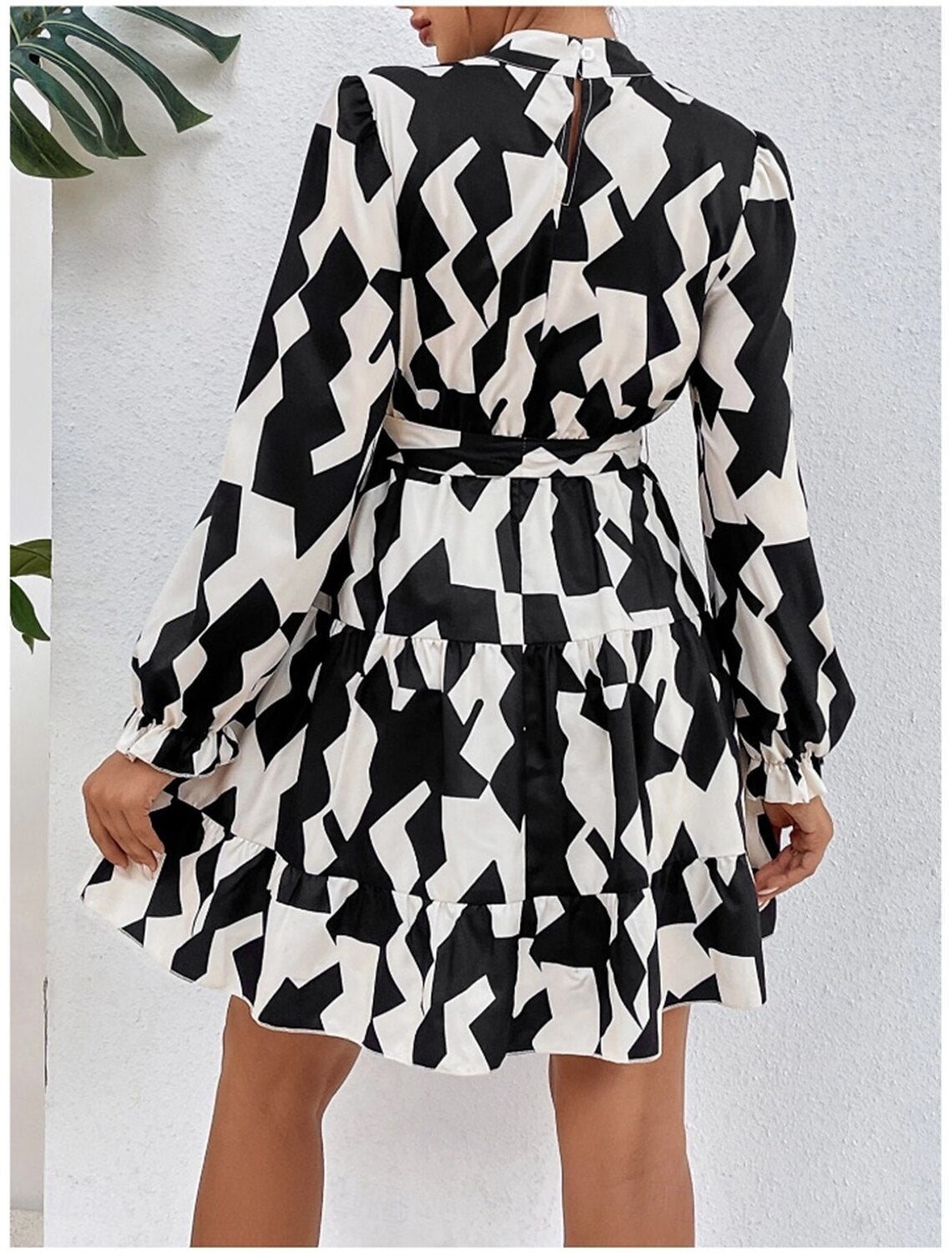 Side view of a woman showcasing the elegant dark petite A-line ruffle graphic long sleeve stand collar party dress.