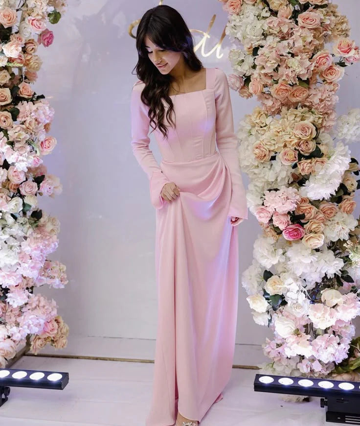 Front view of an elegant pink pleated square neck long sleeve floor length evening dress.