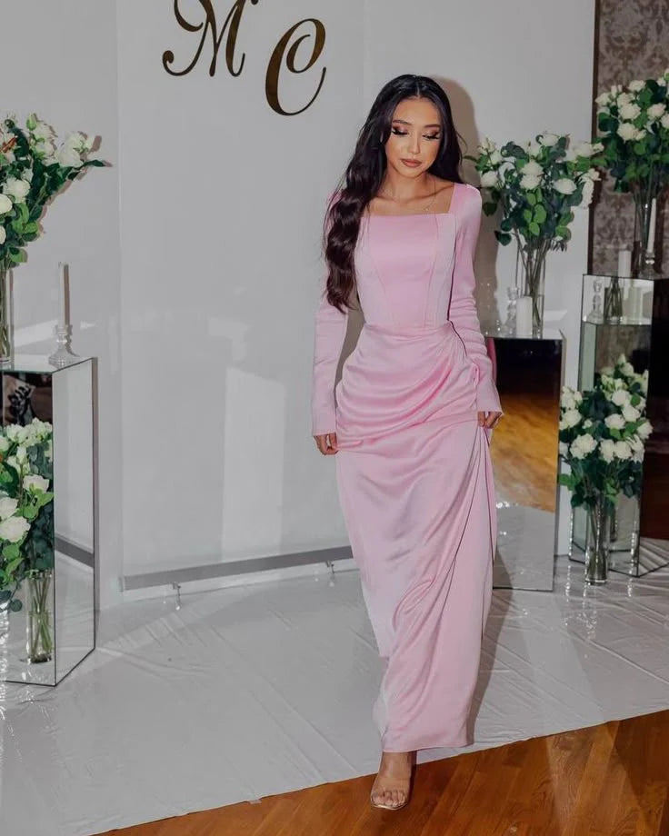Side view of an elegant pink pleated square neck long sleeve floor length evening dress.