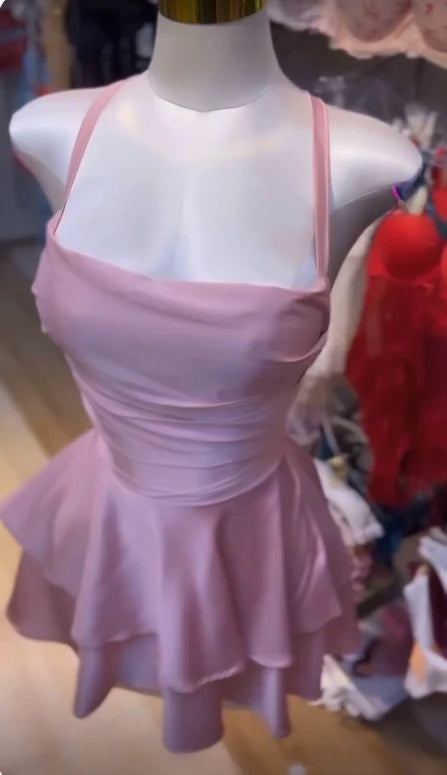 Woman in a short pink spaghetti strap backless party dress.