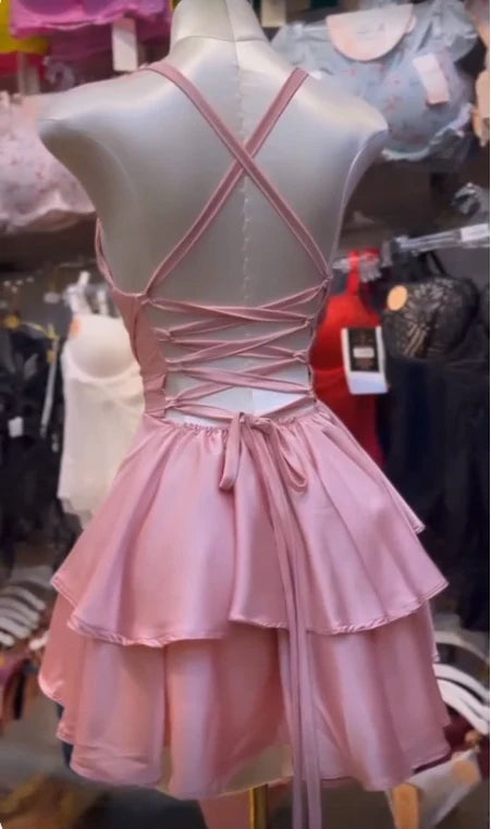 Back view of a woman wearing a short pink prom dress.