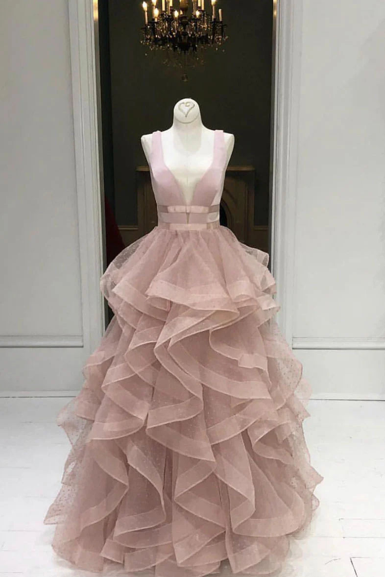 Woman wearing an elegant pink tulle A-line long prom dress with a ruched waist.