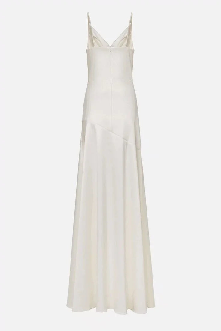 Side view of a white pleated ball gown, showcasing the flowing skirt and elegant slit.