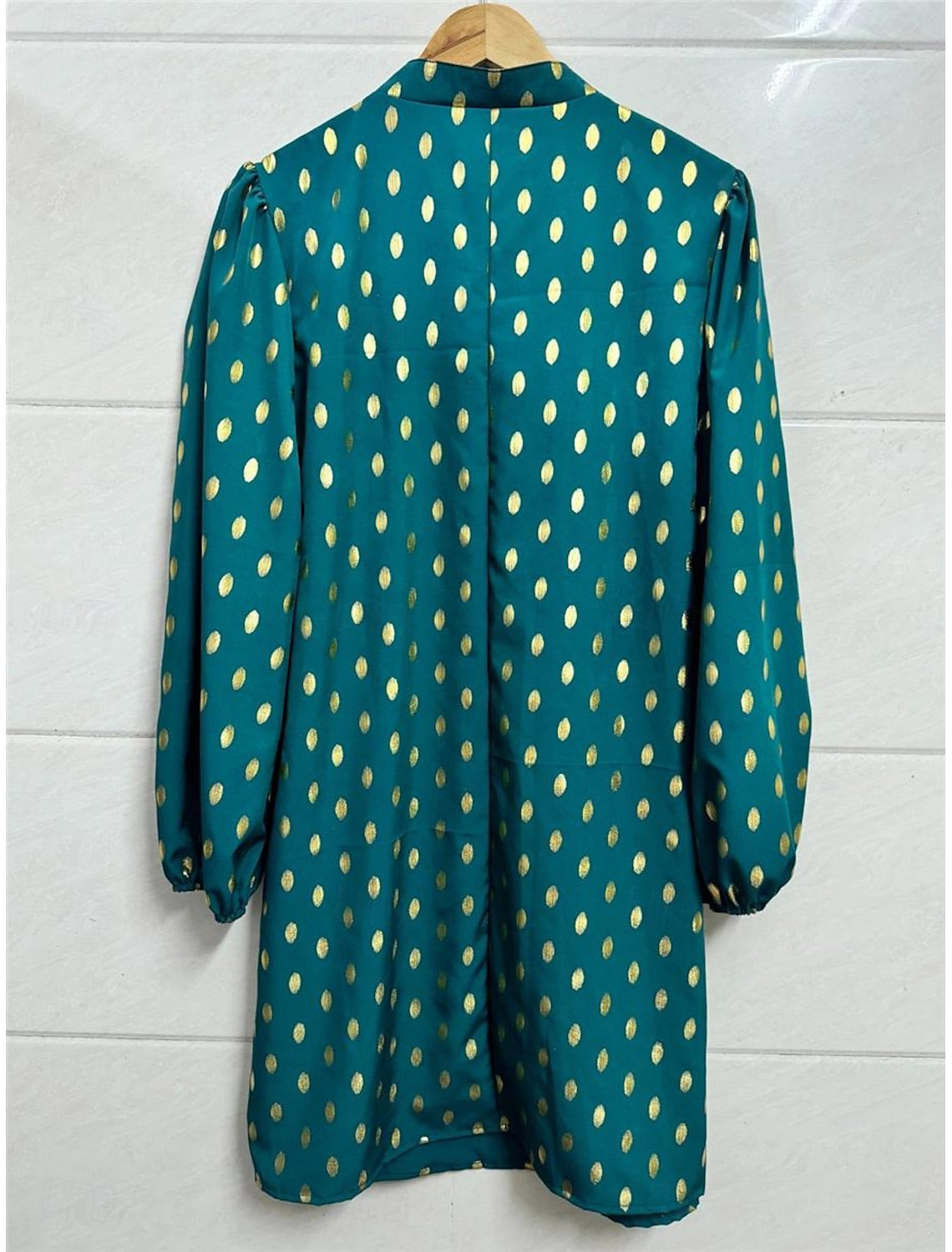 Back view of a woman in a long sleeve polka dot dress.