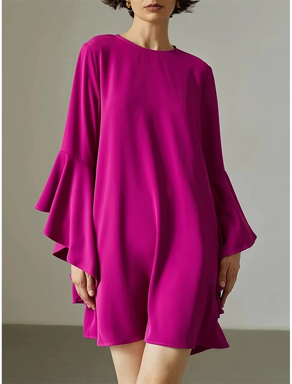 Woman modeling an elegant pink long sleeve mini dress with a crew neck.