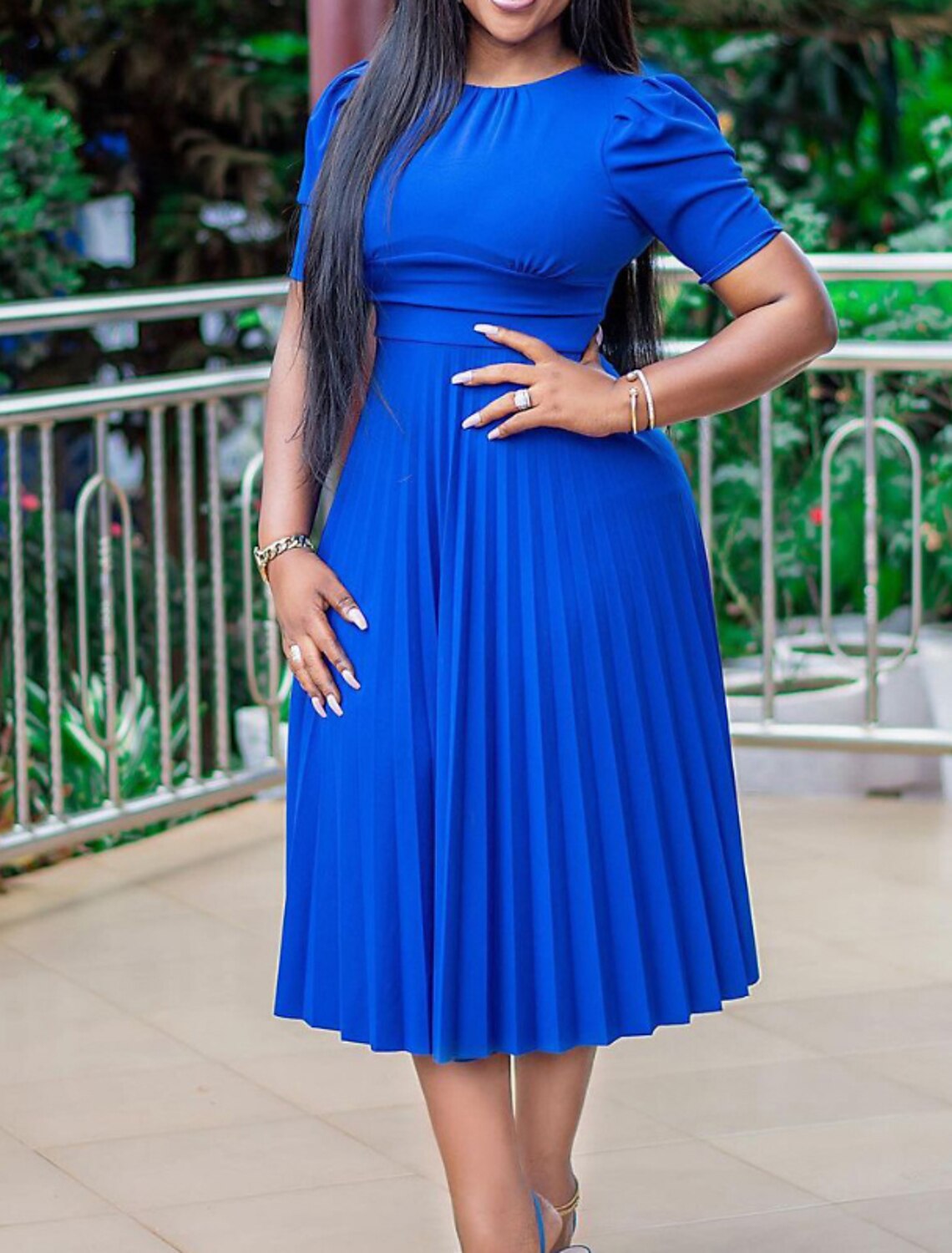 Woman wearing an elegant regular fit short sleeve crew neck midi dress in a solid color.