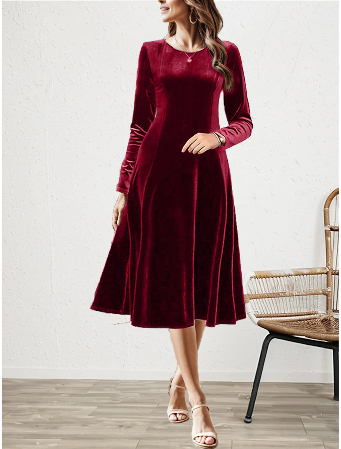 Woman wearing an elegant burgundy velvet long-sleeve midi dress with a flared skirt.