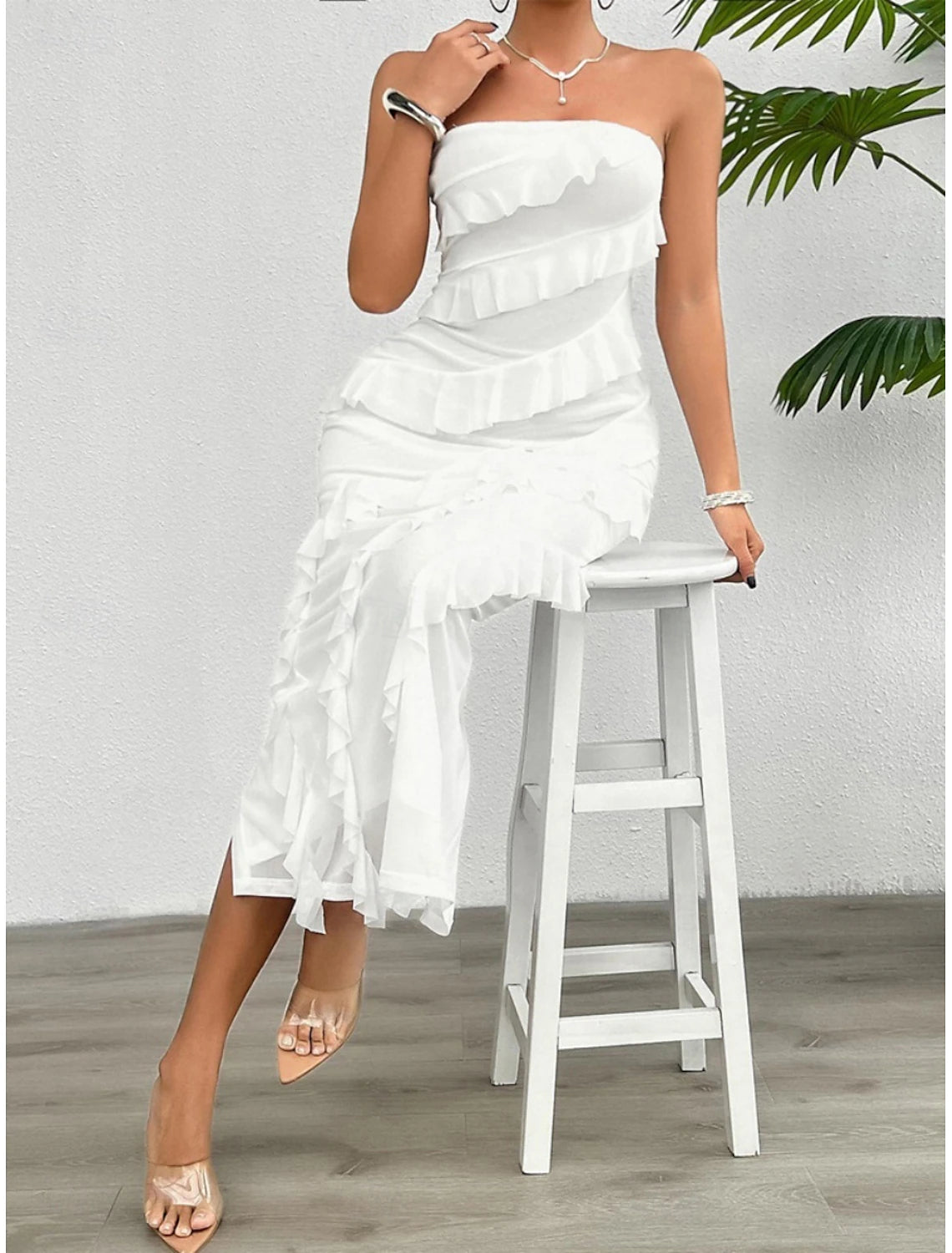 Side view of model in a white off-shoulder strapless formal gown.