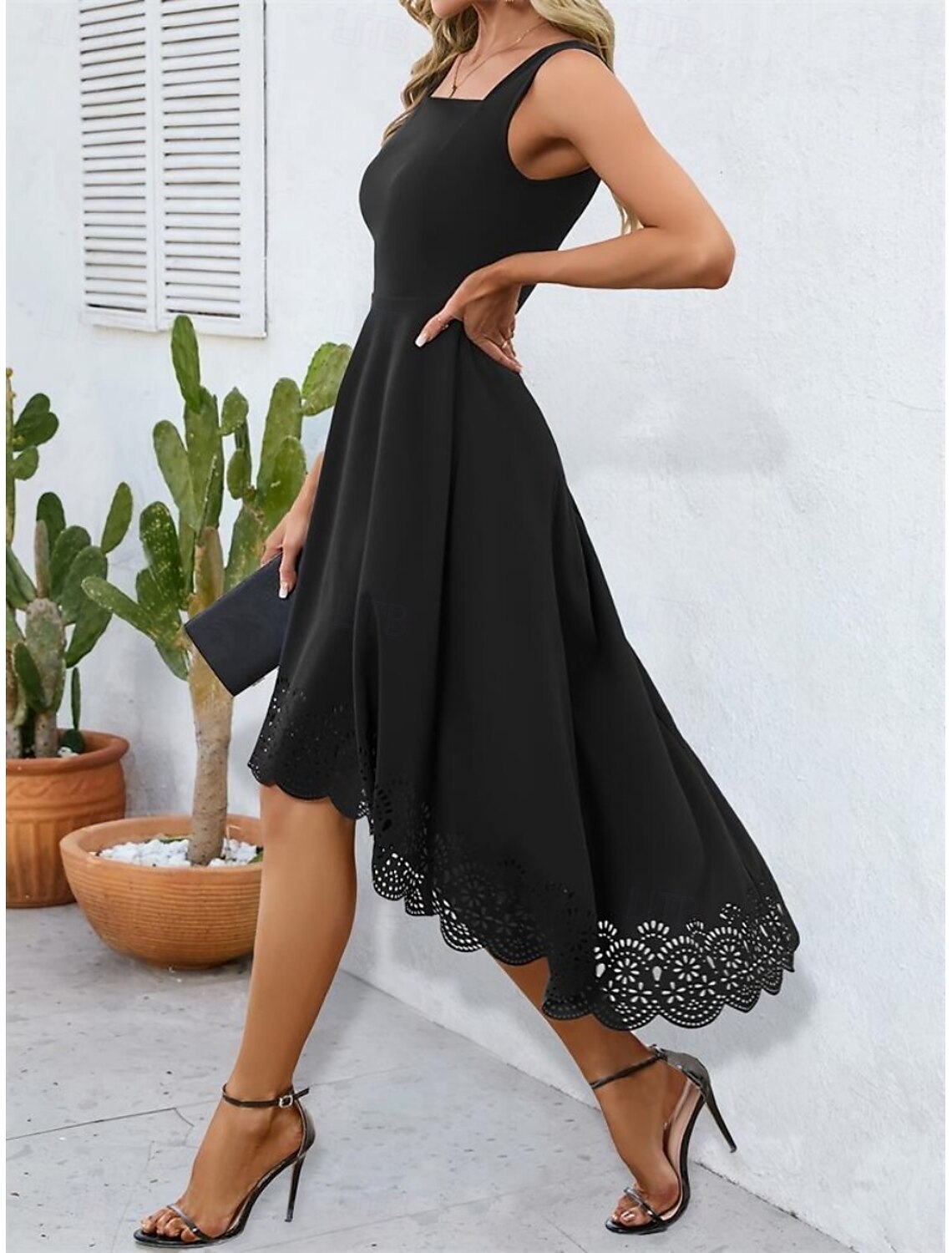 Model in a black slip dress with spaghetti straps, side profile.