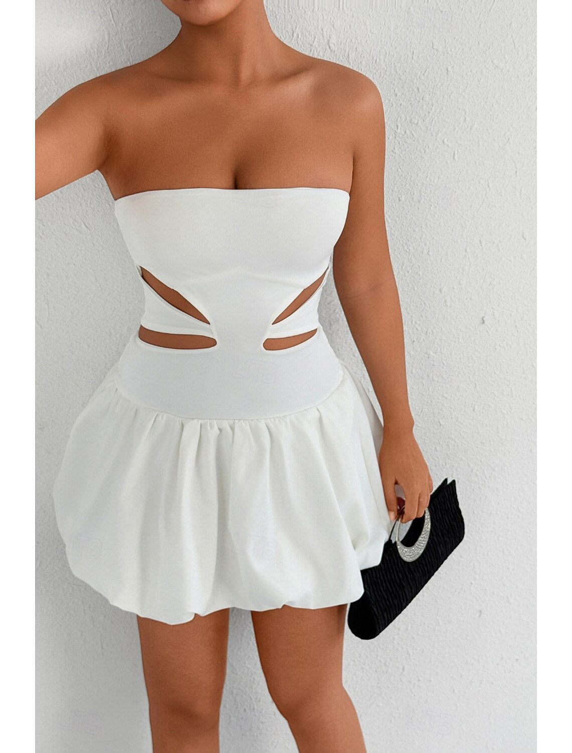 Woman in a white strapless mini dress, side profile.