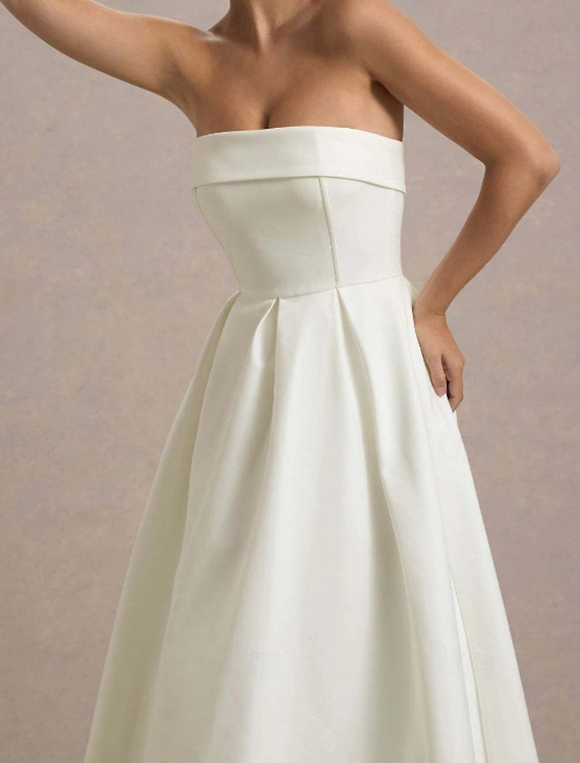 Side profile of a woman in a white midi graduation dress.