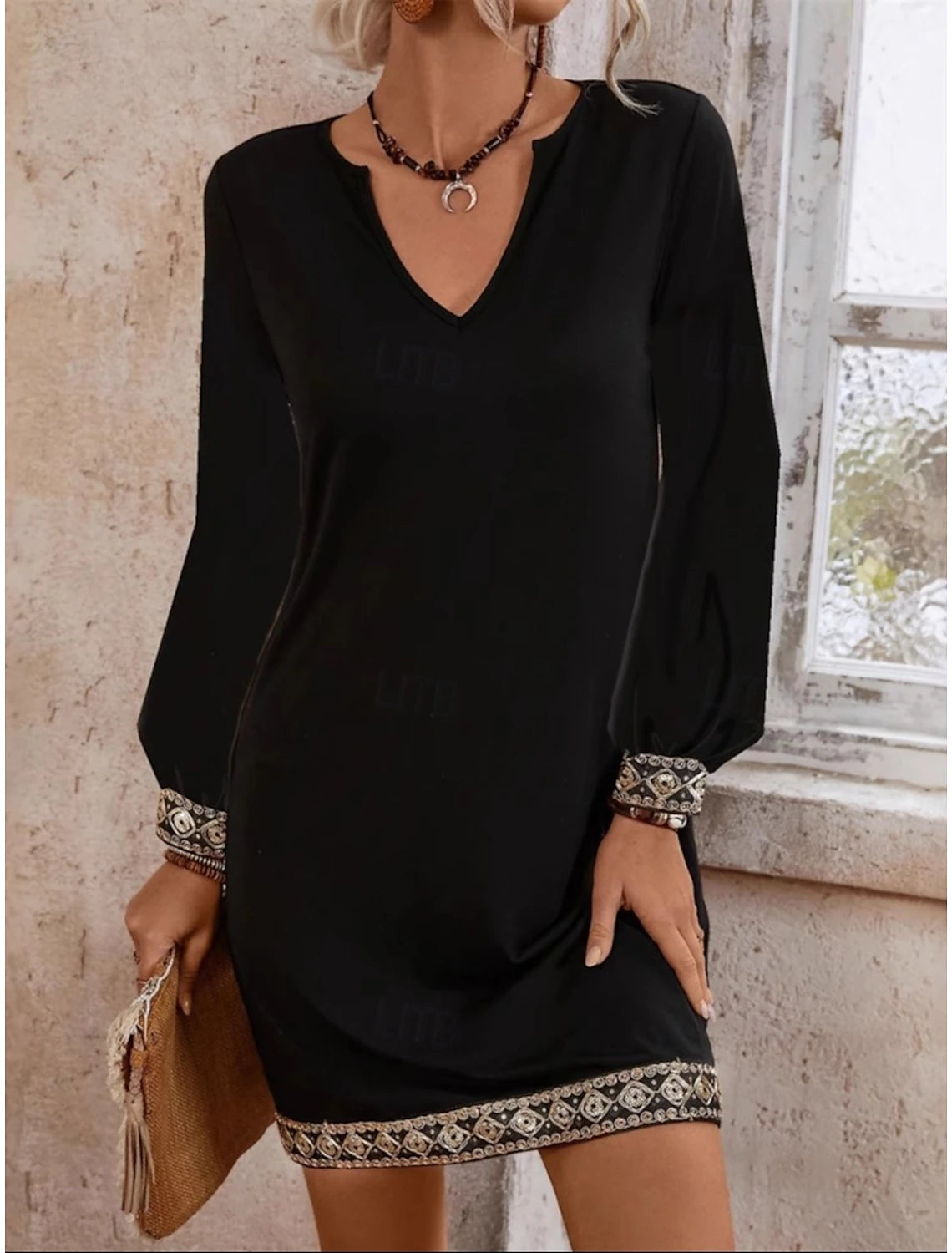 Woman wearing a black regular fit V-neck long sleeve dress.
