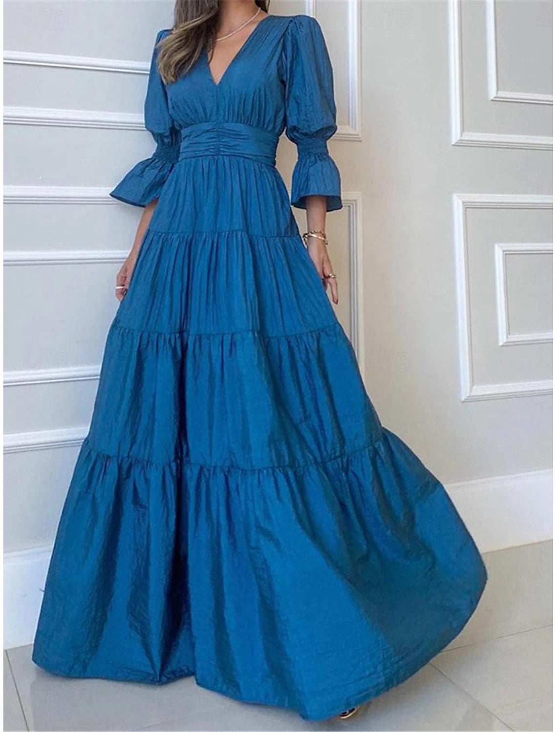 Woman wearing an elegant ruched A-line V-neck maxi dress with 3/4 sleeves, suitable for formal events.