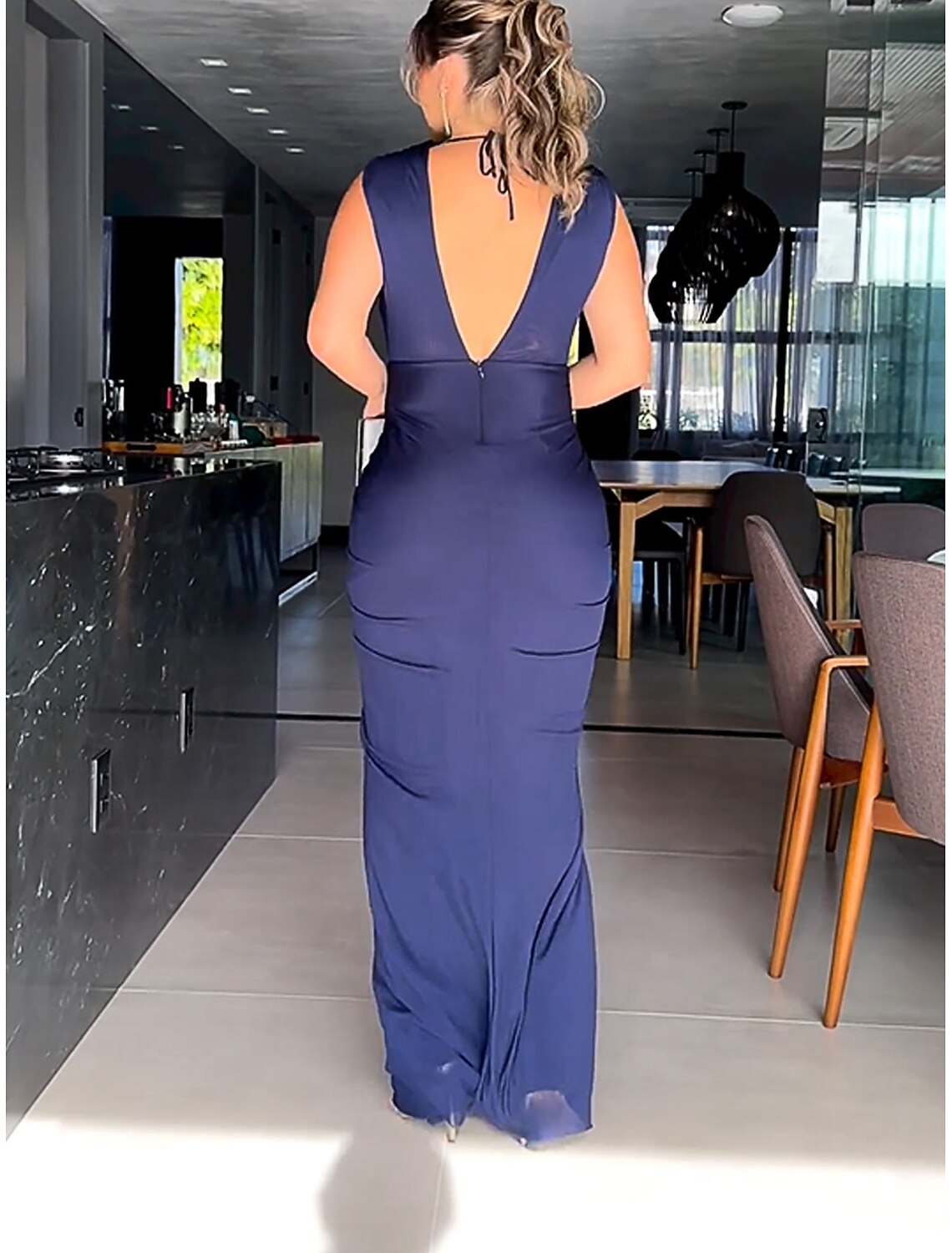 Detailed view of the ruched back design on a black formal dress.