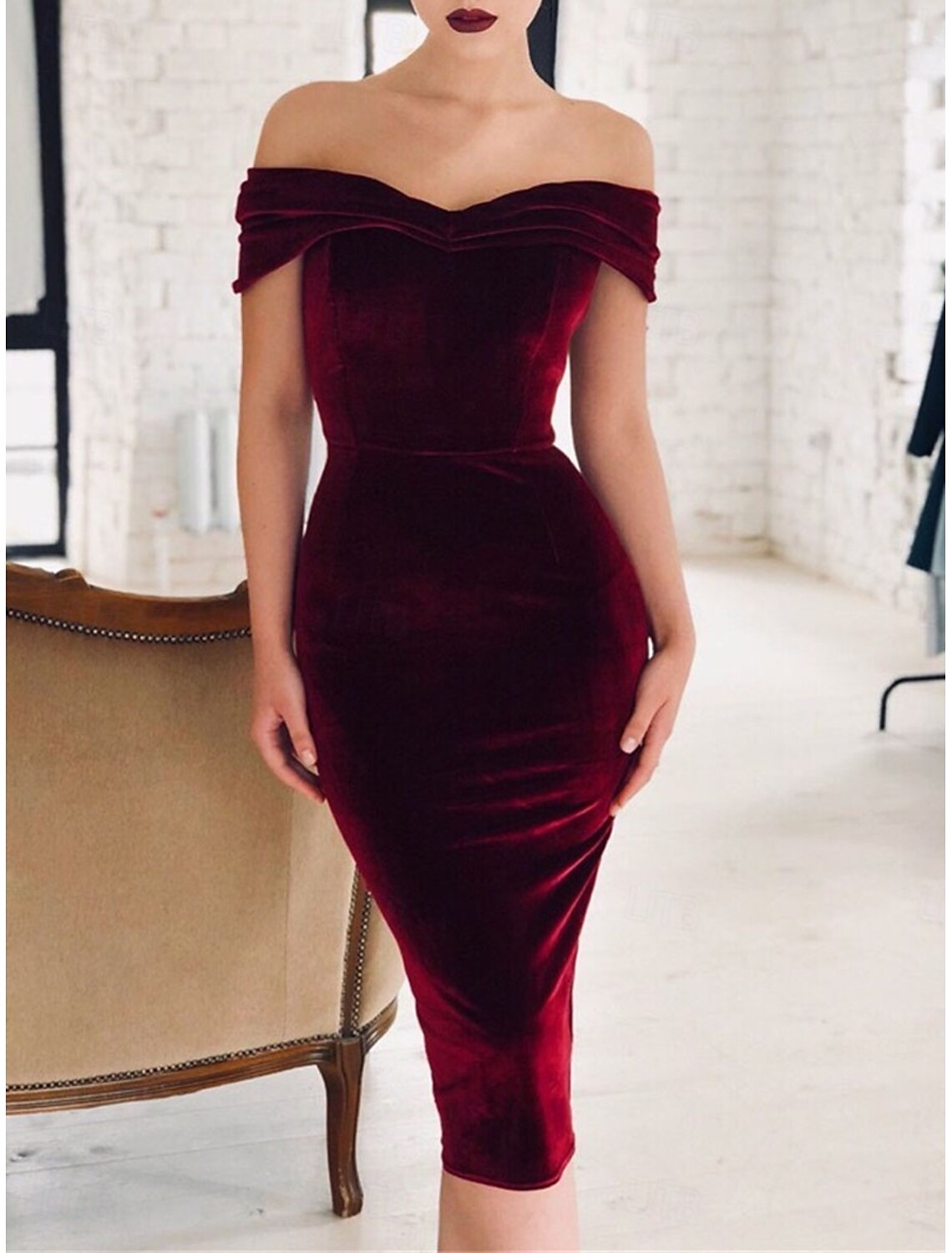 Woman standing in a wine red off-shoulder short sleeve midi dress.
