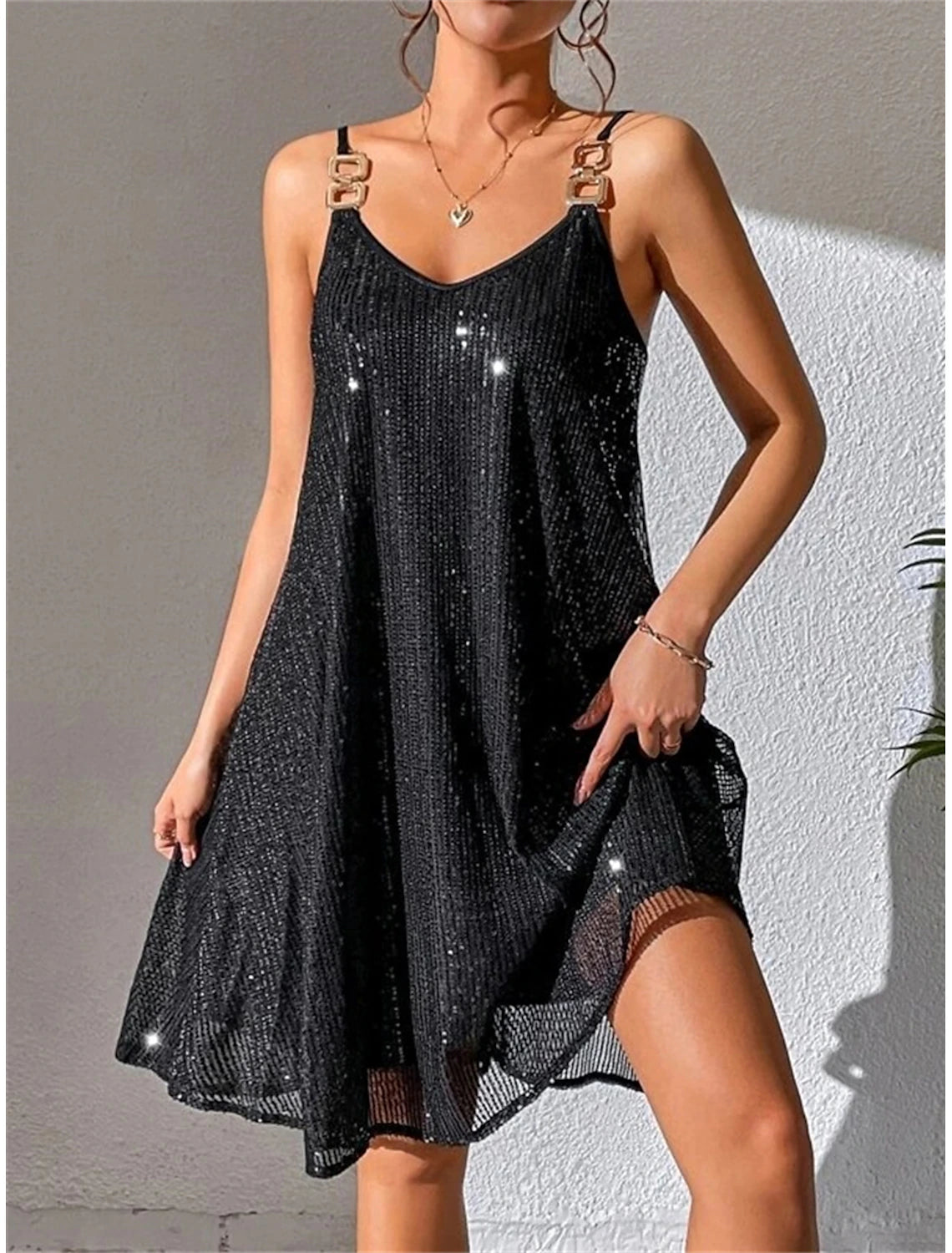Woman wearing a black ruched shirt collar long sleeve mini dress.