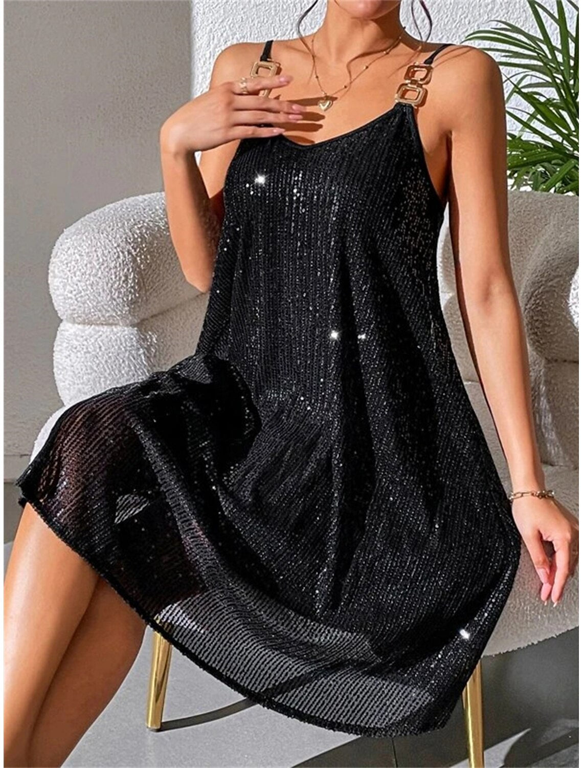 Side view of a woman in a black ruched mini dress with a shirt collar.