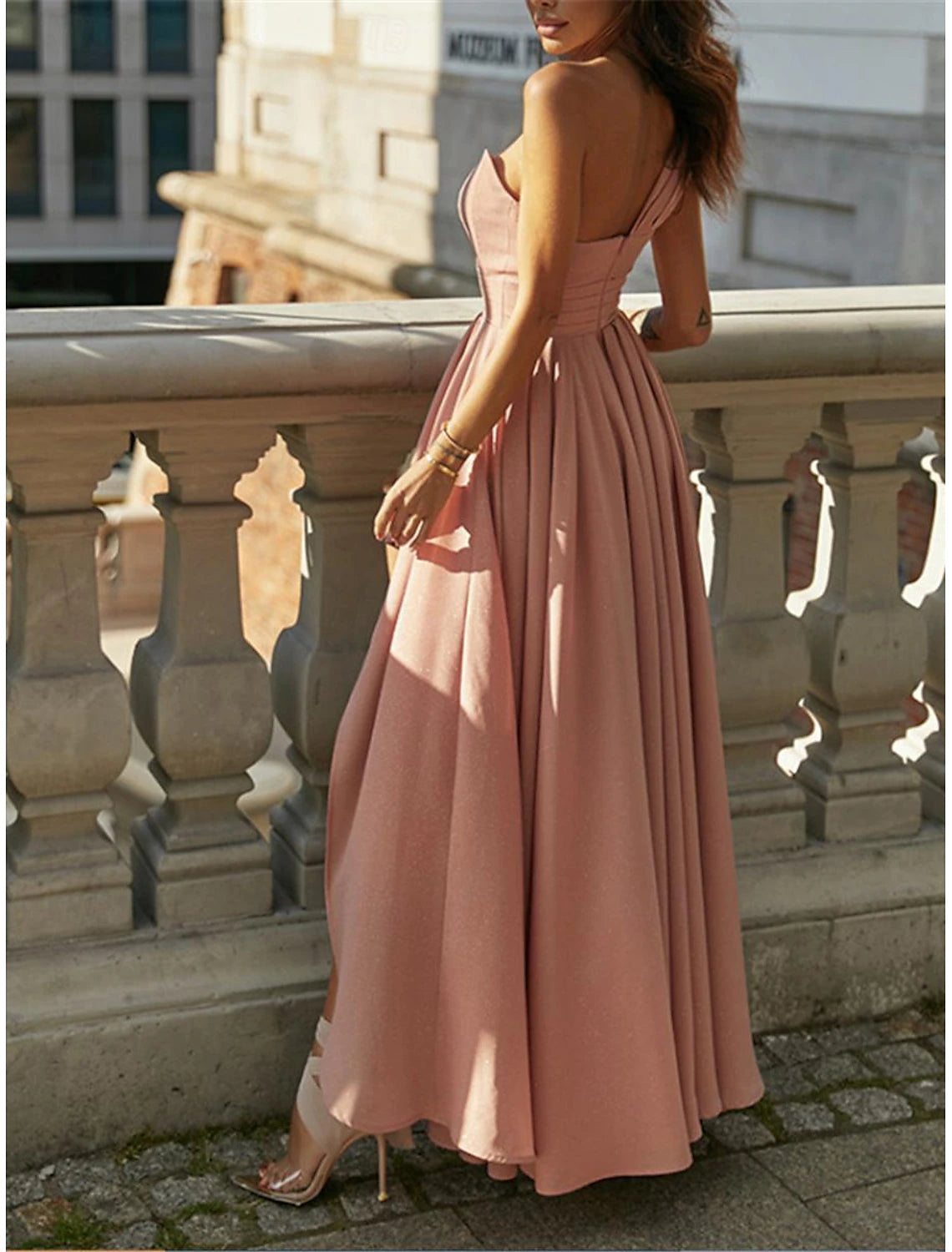 Woman posing in a flowing chiffon maxi dress with ruffle details.
