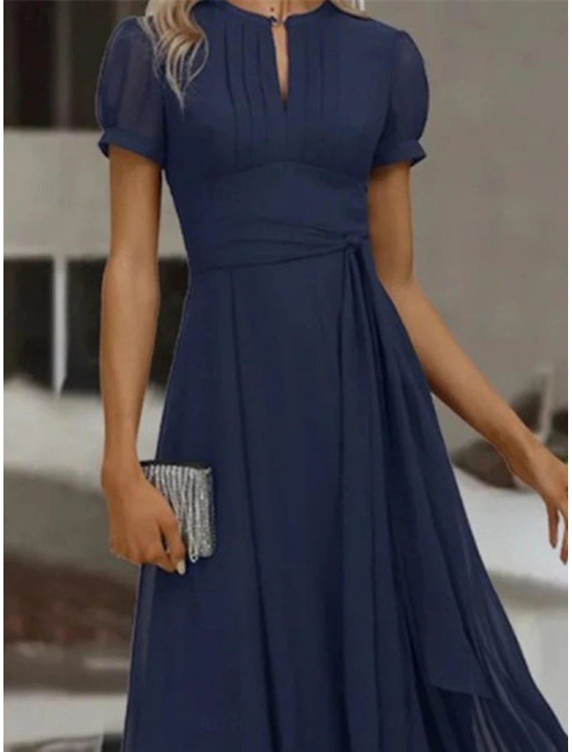 Back view of a woman wearing a flowing chiffon maxi dress with ruffle details, suitable for formal events.