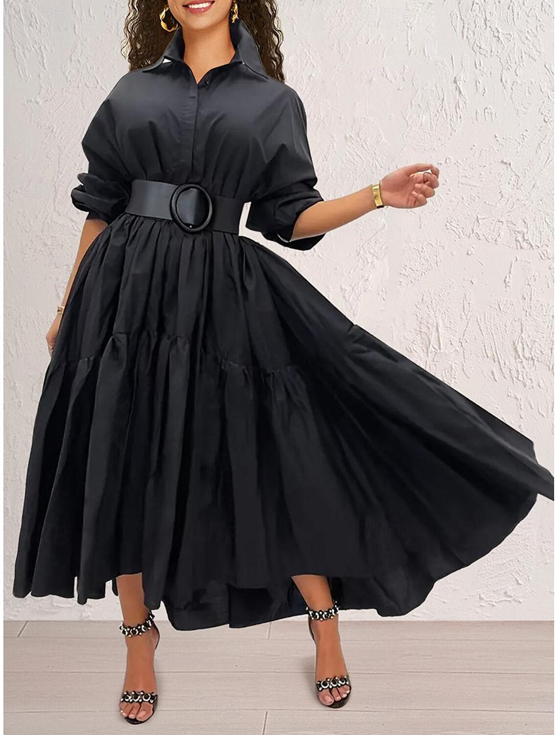 Woman wearing an elegant black ruffle shirt collar long sleeve maxi dress.