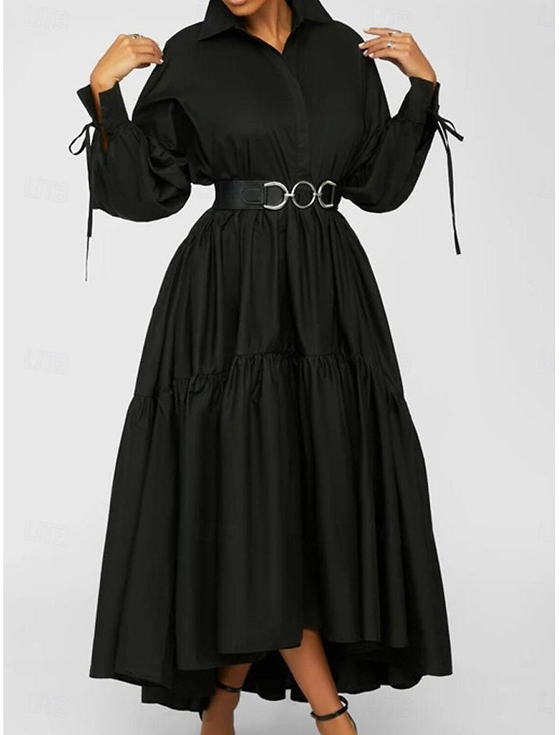 Side view of a woman in a black ruffle shirt collar long sleeve maxi dress.