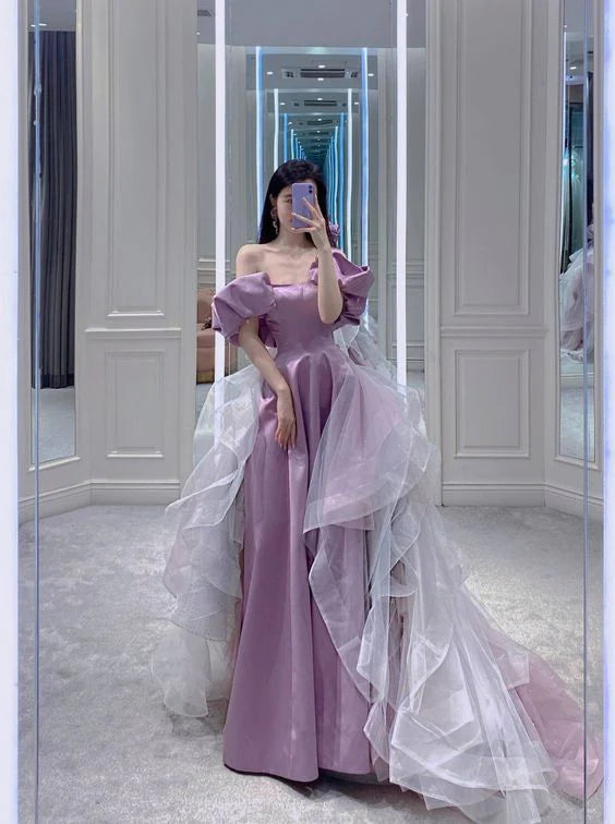 Woman wearing a long purple satin A-line off-the-shoulder evening dress.