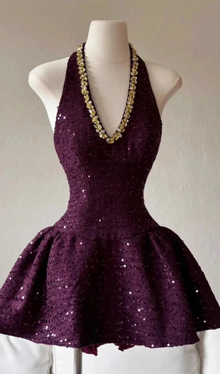 Woman wearing a dark purple sequin V-neck halter short homecoming dress.