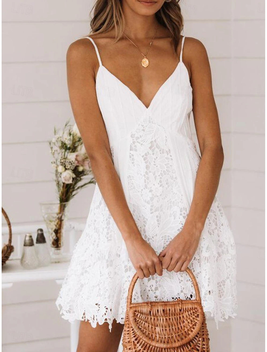 Front view of a woman wearing an elegant white lace sleeveless homecoming dress with delicate straps.