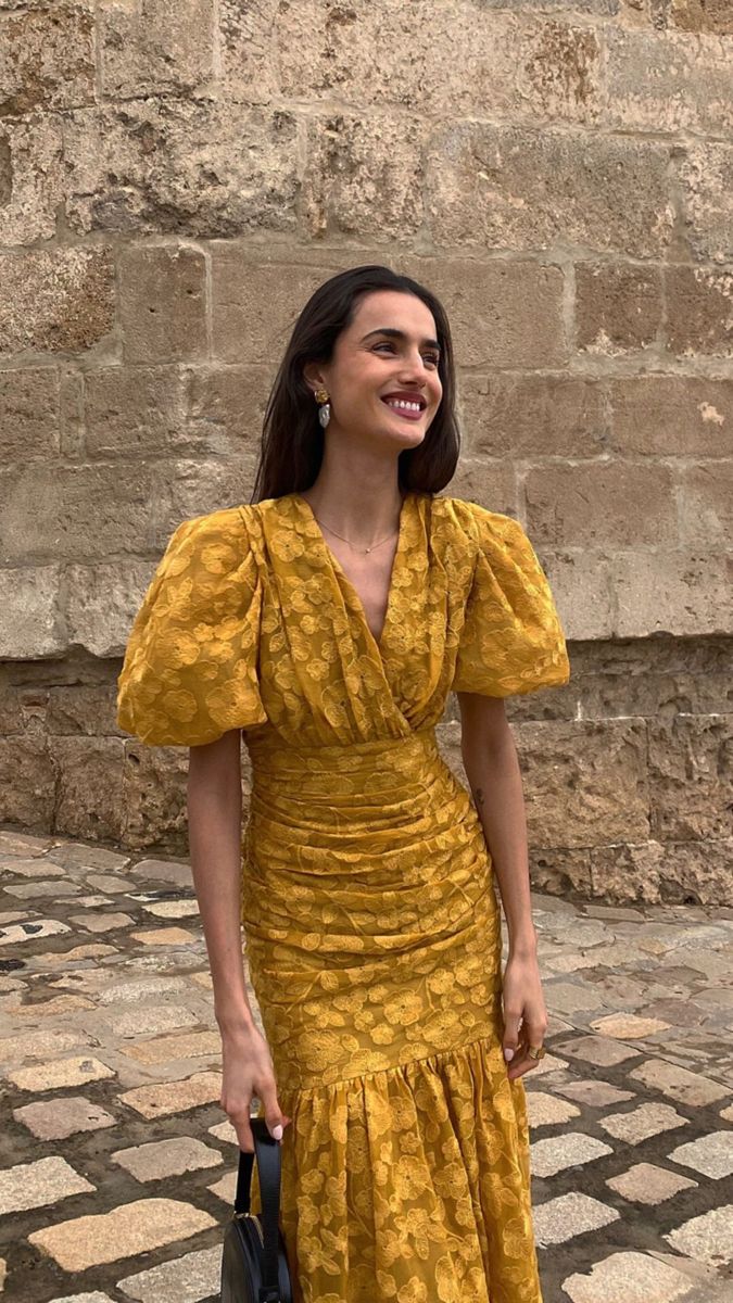 Back view of a mustard floral V-neck dress with puff sleeves and zipper closure.