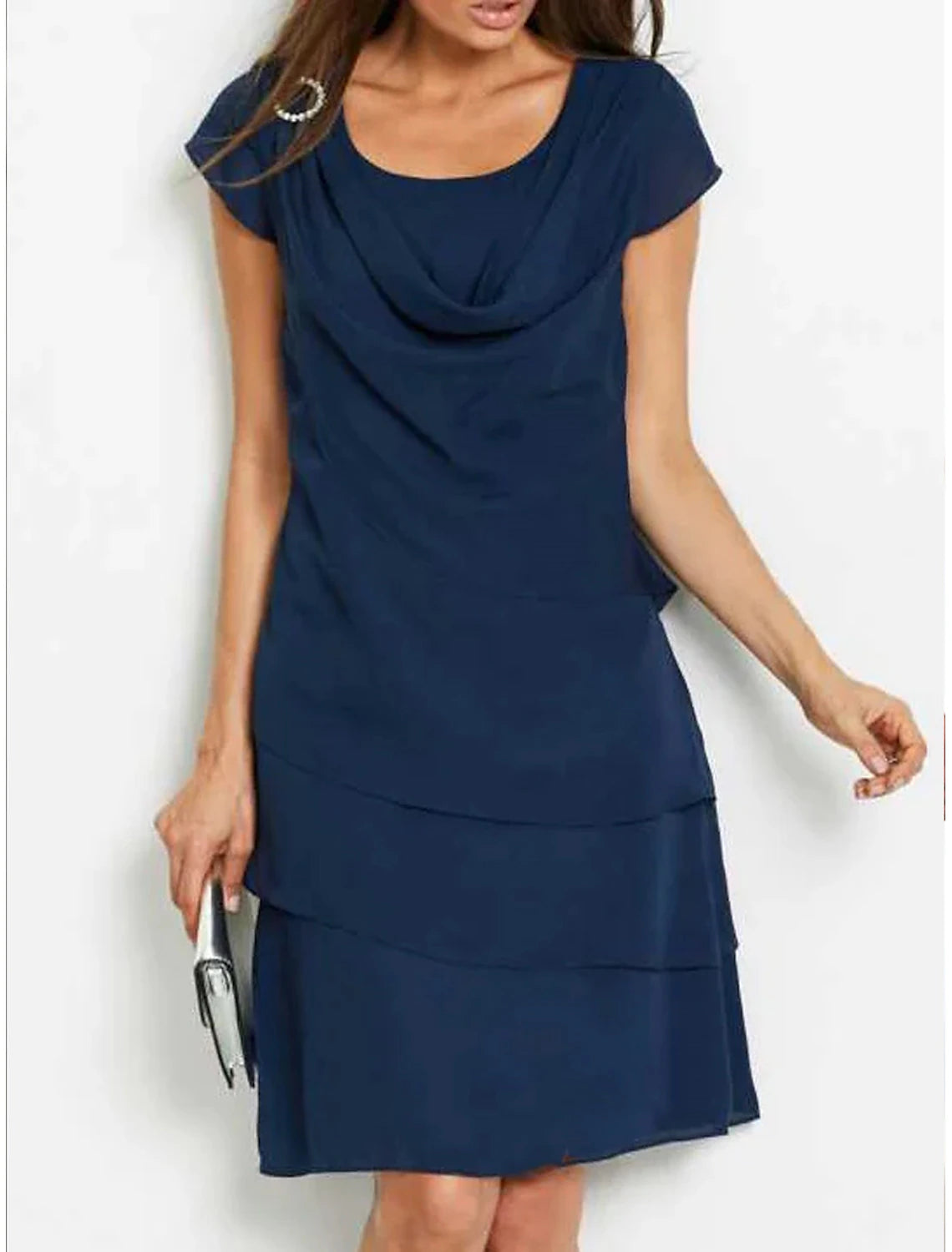 Woman wearing an elegant navy blue short sleeve ruched midi shift dress, front view.